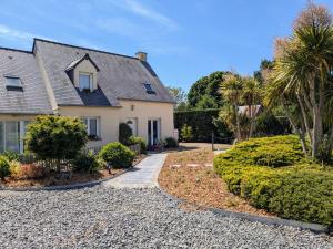 a house with a gravel driveway and palm trees at Chambres d'hôtes chez l'habitant - Bed & Breakfast homestay in Huisnes-sur-Mer