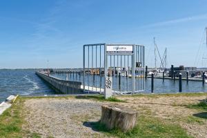 a dock with a sign on the side of the water at Hausboot Tollow in Stralsund +2 photos