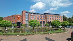 a large brick building with a pond in front of it at Hotel Asteria in Venray