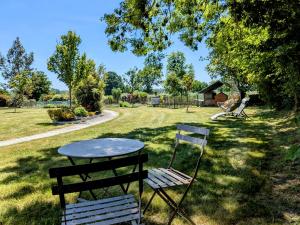a table and two chairs sitting in the grass at Chambres d'hôtes chez l'habitant - Bed & Breakfast homestay in Huisnes-sur-Mer