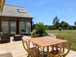 a wooden table and chairs on a patio at Chambres d'hôtes chez l'habitant - Bed & Breakfast homestay in Huisnes-sur-Mer