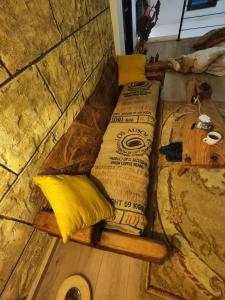 two beds on a wooden wall with yellow pillows at Kesane in Ozurgetʼi
