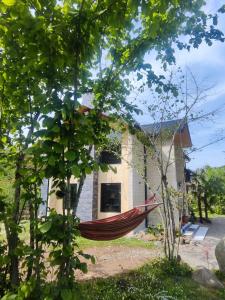 a red hammock in front of a house at Kesane in Ozurgetʼi