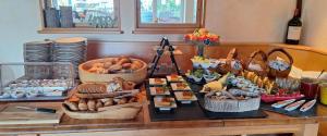 a table with many baskets of different types of food at Hotel Klett B&B in Langenargen +30 photos