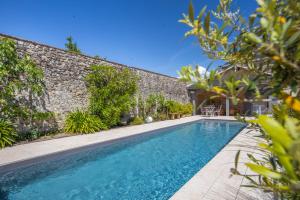 a swimming pool in front of a brick wall at La Grange De La Maison Reverdi in Lamarque