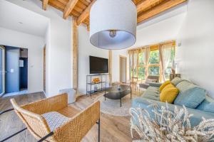 a living room with a couch and chairs and a tv at La Grange De La Maison Reverdi in Lamarque