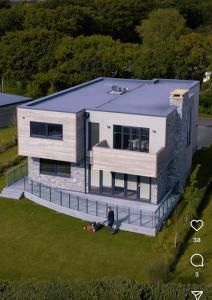 a man standing in front of a house at Modern 5 Bedroom Luxury Home with Sea Views and Hot Tub in North Hayling