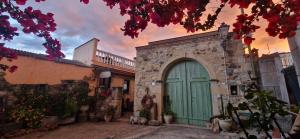 a building with a green door in a courtyard at Casa Susanna Rural Sardinia in Sini