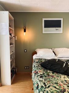 a bedroom with two beds and a tv on the wall at Escapade sur la Vilaine in Guipry-Messac
