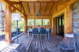 Una terraza de madera con una mesa y sillas. en Chalet de l'alpette, en Valloire