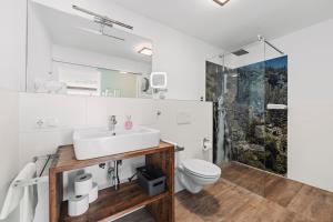 a bathroom with a sink and a toilet at Herzblut Wohlfühl Appartements by Peak Stay in Oetz +22 photos
