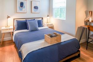 ein Schlafzimmer mit einem blauen Bett und einem Korb darauf in der Unterkunft Cozy Luxe Unit Near Disneyland - Sleeps up to 10! EV Friendly & King Bed in Midway City