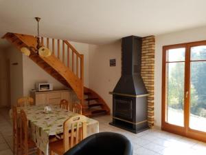 a dining room with a table and a stove at Chalet Mi'Loup, tout confort, à Plainfaing in Plainfaing