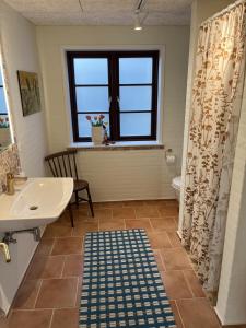 a bathroom with a sink and a toilet and a window at Lucky 3 Apartments in Løkken