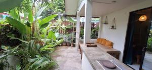 a porch with a bench and a bunch of plants at Little house in El Nido +2 photos