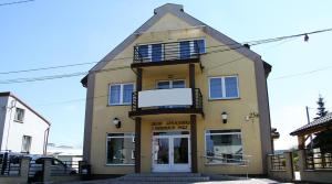 a large yellow building with a sign in front of it at Apartamenty Pod Telegrafem in Kielce