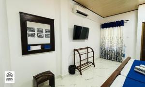 1 dormitorio con espejo y TV en la pared en Urban Palm Villa, en Anuradhapura 12 fotos más