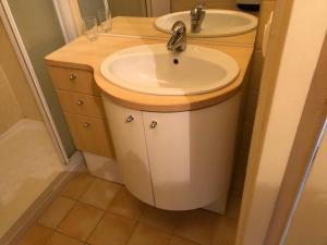une salle de bains avec un lavabo blanc et un miroir dans l'établissement Appart T2 avec garage, balcon et ménage inclus au Lavandou - FR-1-308-57, à Bormes-les-Mimosas
