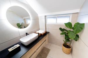 a bathroom with a sink and a mirror and a plant at FeelHome in Cochin