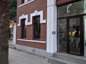 a red brick building with windows on a street at Poti Seaside Apartment O in Poti +2 photos