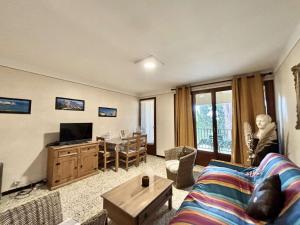 ein Wohnzimmer mit Sofa und Fernseher in der Unterkunft Studio Résidence de La Mer L'ILE-ROUSSE in LʼÎle-Rousse + 14 Fotos