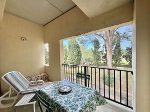 einen Balkon mit einem Tisch, einem Stuhl und einem Fenster in der Unterkunft Studio Résidence de La Mer L'ILE-ROUSSE in LʼÎle-Rousse