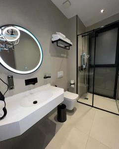 un bagno con lavandino, water e specchio di StarLight Hotel a Tirana