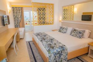 a hotel room with a bed and a desk at Marhaba Royal Salem - Family Only in Sousse