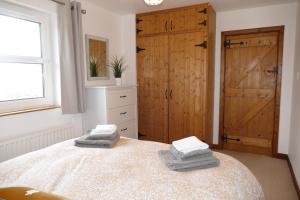 une chambre avec un lit avec deux serviettes dessus dans l'établissement Carol Cottage and Master Suite, à Kilkeel