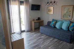 a living room with a blue couch and a window at Aliston Hotel Thassos in Skala Potamias