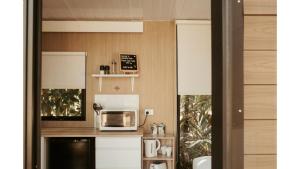 una cucina con forno a microonde su un bancone di The Stables by Tiny Away a Palmwoods