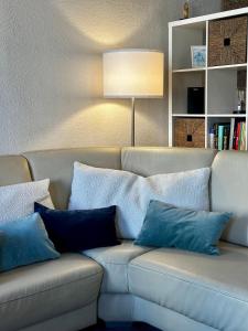a living room with a couch with blue pillows at T3 Chaleureux - Vieux Toulon - Proche Port in Toulon +20 photos
