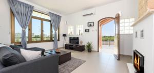 un salon avec un canapé et une cheminée dans l'établissement Potamos Villa - Villa Kymma 4, à Ayia Napa