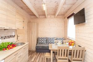 ルビャトボにあるDomki Miłe z basenem - Lubiatowoのキッチン(テーブル、ソファ付)