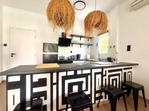 una cocina con encimera y taburetes en blanco y negro en Ammo's Villa, en Orfánion