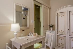 y baño con mesa, lámpara y espejo. en Soggiorno Pezzati, en Florencia 69 fotos más