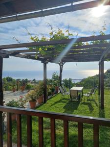 a patio with a table and chairs on a deck at Olga Studios in Tsagarada