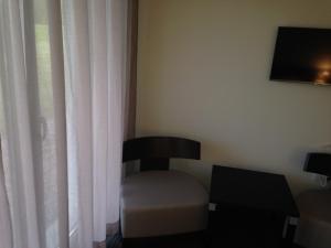 una silla sentada en una habitación con ventana en Hotel - Restaurant La Claire Forêt, en Morhange