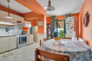 a kitchen with a table and chairs and orange walls at Palati in Ratzaklíon +16 photos