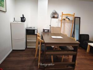 a kitchen with a table and a refrigerator at Guest House WA in Kyoto +91 photos