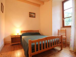 a bedroom with a bed and a table and a window at Gîte de charme 10 pers. à Saint-Vert - Nature préservée, 4 chambres, jardin clos - FR-1-582-307 in Saint-Vert