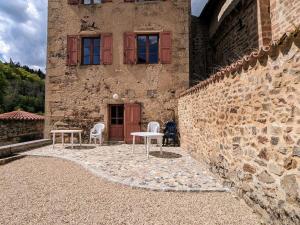 two chairs and a table in front of a building at Gîte de charme 10 pers. à Saint-Vert - Nature préservée, 4 chambres, jardin clos - FR-1-582-307 in Saint-Vert