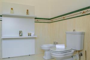 Un baño con un inodoro blanco y un lavabo. en I Barcaioli, en Giardini Naxos