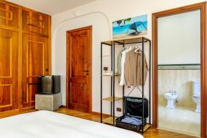 1 dormitorio con 1 cama, TV y baño en I Barcaioli, en Giardini Naxos