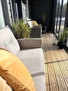 a porch with two couches and potted plants at Luhtitalon päätyhuoneisto saunalla - Liinavaatteet,pyyhkeet ja loppusiivous sisältyvät aina majoituksen hintaan in Kalajoki