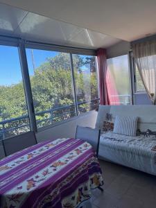 Un dormitorio con dos camas y una gran ventana. en L'endroit, en La Seyne-sur-Mer