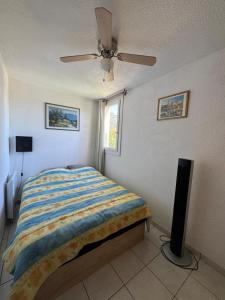 Un dormitorio con una cama y un ventilador de techo. en L'endroit, en La Seyne-sur-Mer