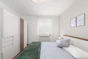 a white bedroom with a bed and a window at Vista OLIVO in Brtonigla +21 photos