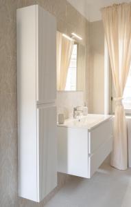 a white bathroom with a sink and a mirror at Fiera Milano 110mq 3 Bedroom Apartment in Senago +26 photos