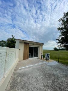 Saint-Georges-des-CôteauxにあるMaison avec grand espace en hauteurのテーブルと柵のある小さな建物